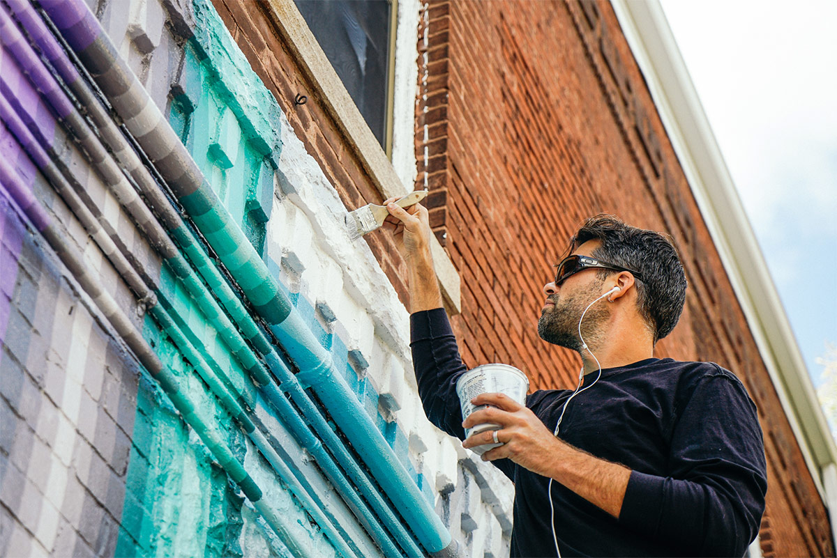 Gibbs Rounsavall working on his mural. (Courtesy Access Ventures)