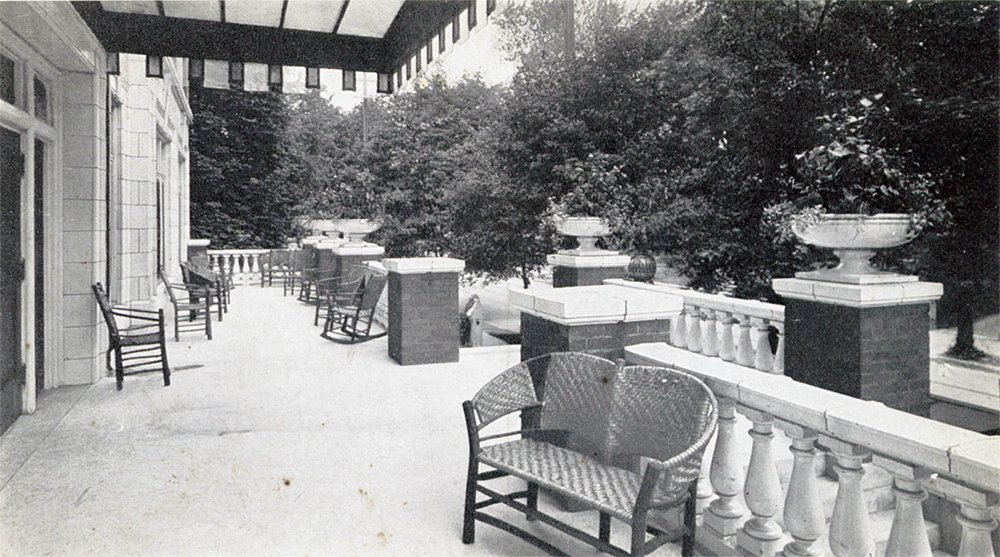 A postcard view of the Puritan Apartments showing its front porch with terra cotta facade and detailing. 